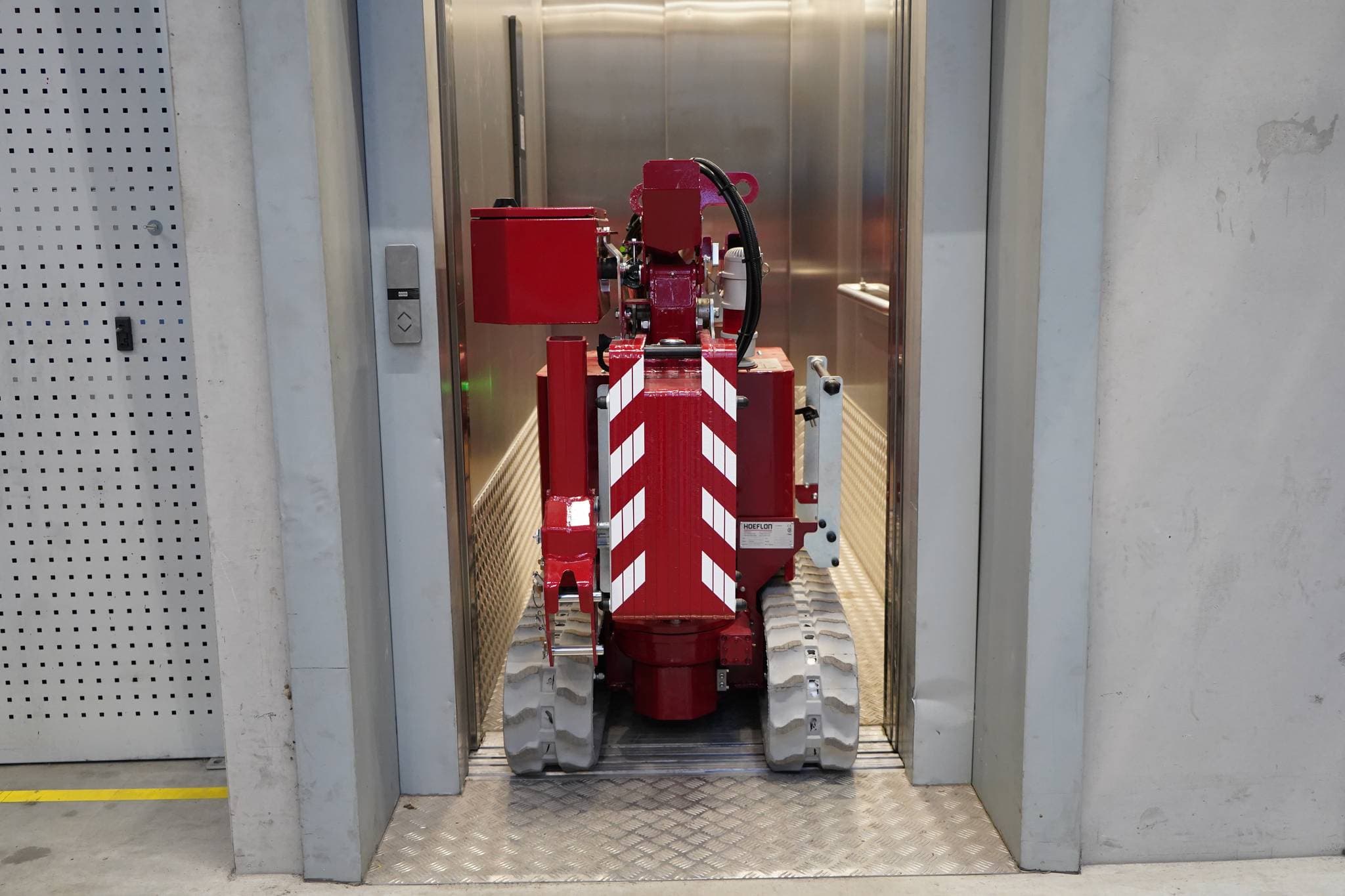 Afbeelding van de Hoeflon C1e kraan in transportstand binnen een lift.